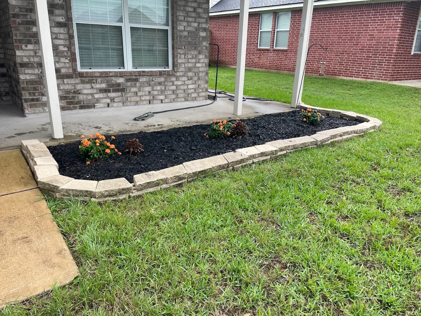 Flower bed with black mulch and stone border